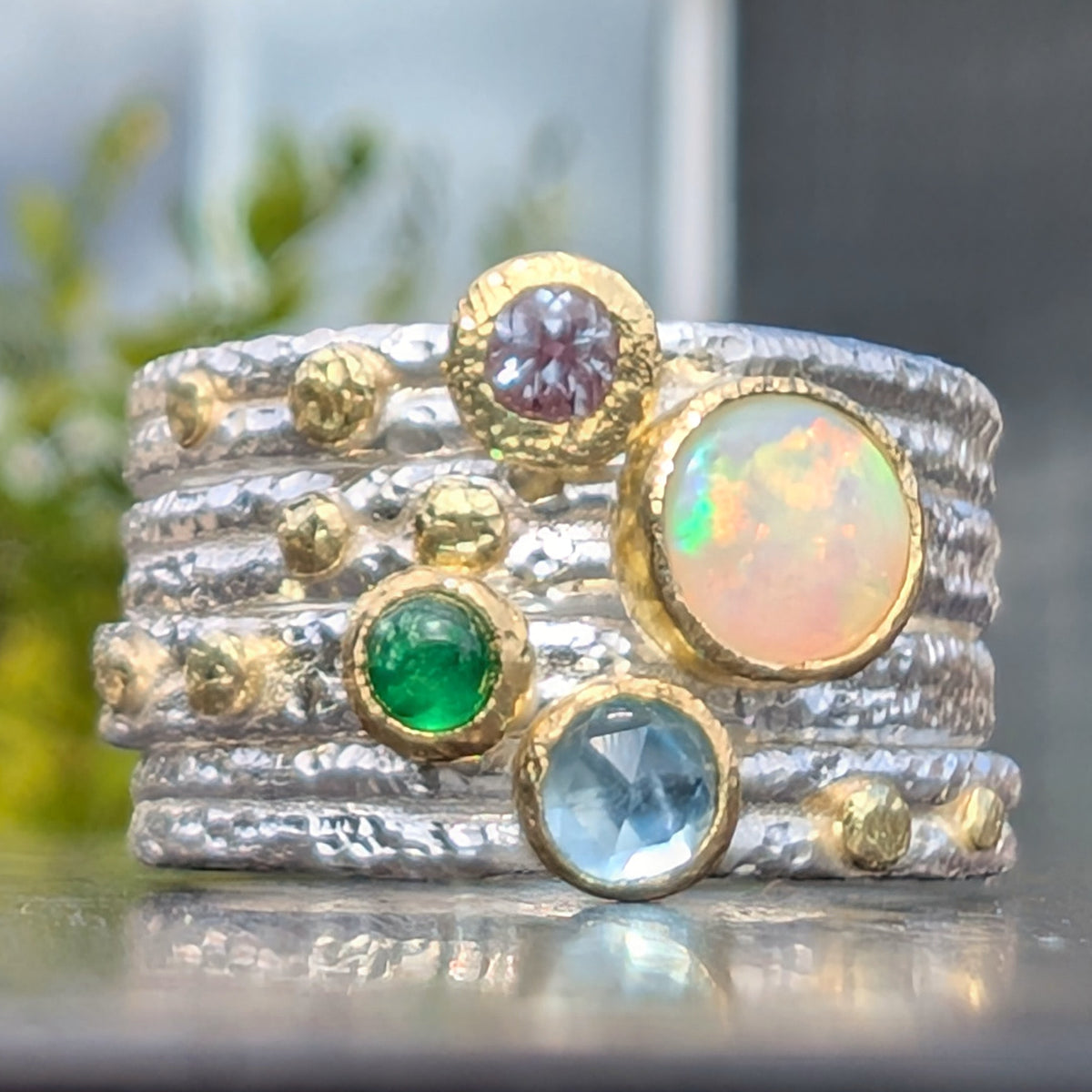 18k bezels and dots on micro hammer textured argentium silver.  Alexandrite, Australian Opal, Tavorite Garnet and Blue Topaz