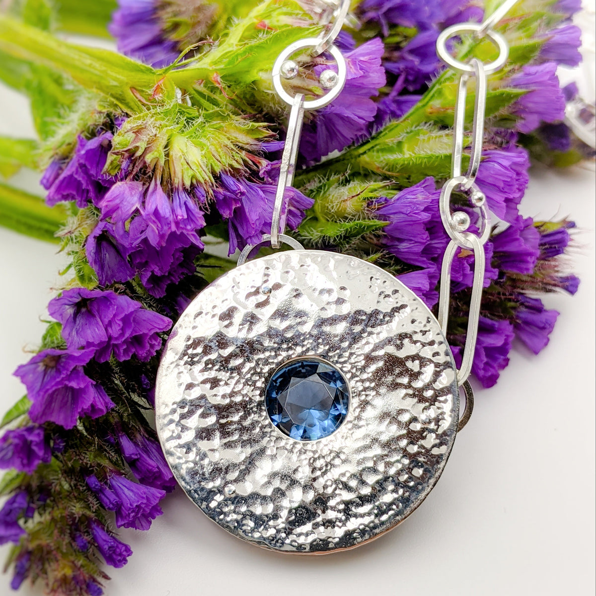 Hammer textured argentium silver discs rivet set a lab grown sapphire on a handmade chain with dot circle details
