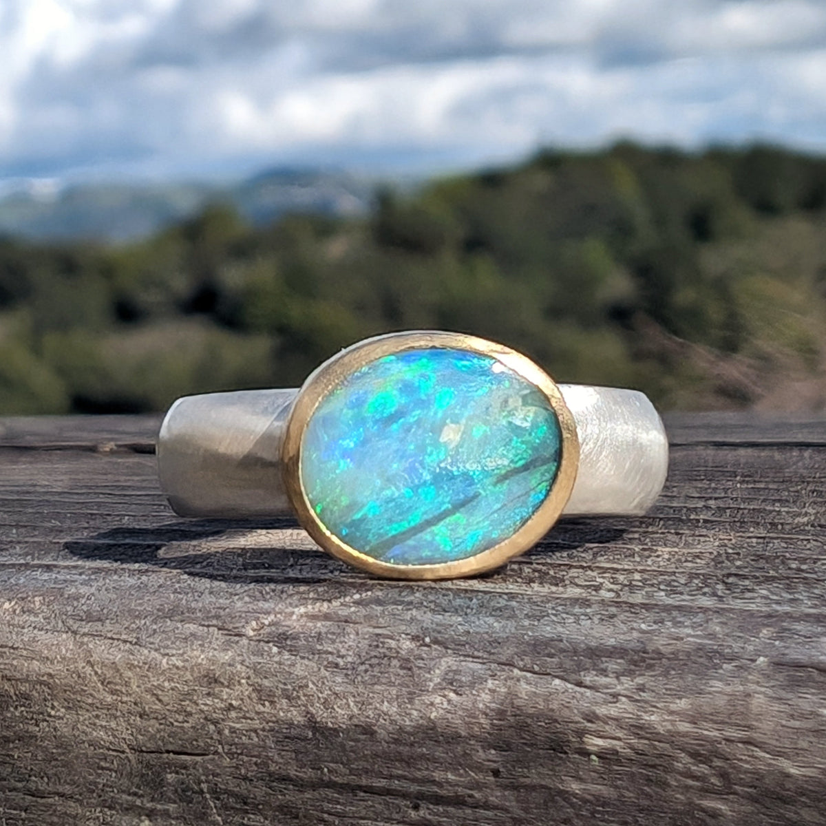 Australian Opal set in a thick 18K bezel on a wide comfort fit argentium silver band